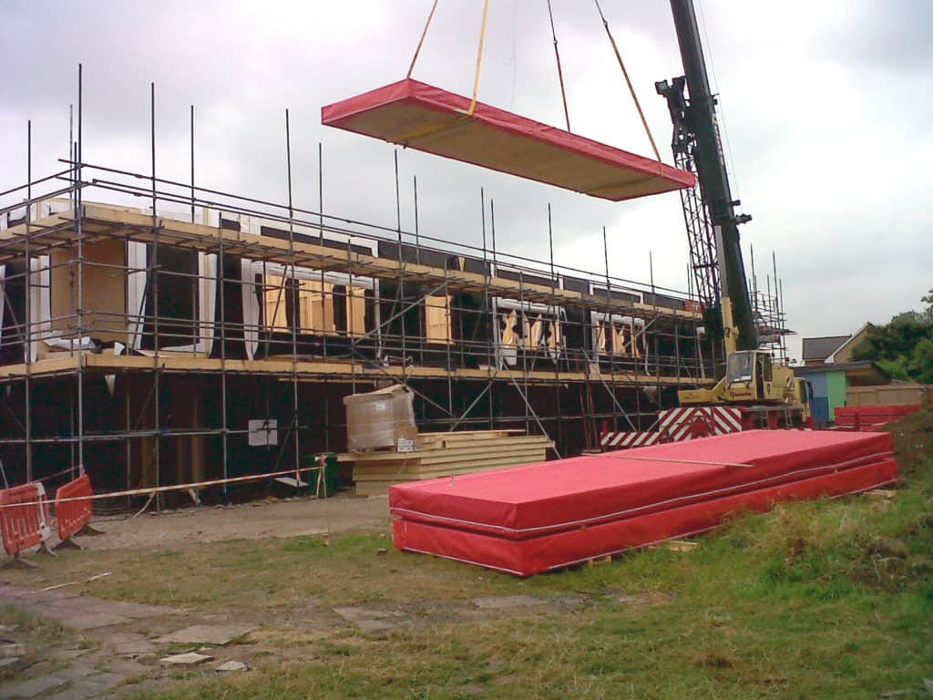floor cassette covered in red protection crane lifted into place at reigate school