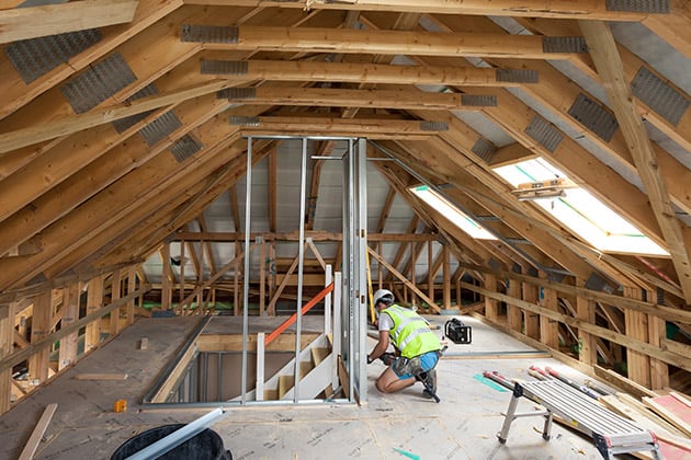 man working inside a timber framed attic